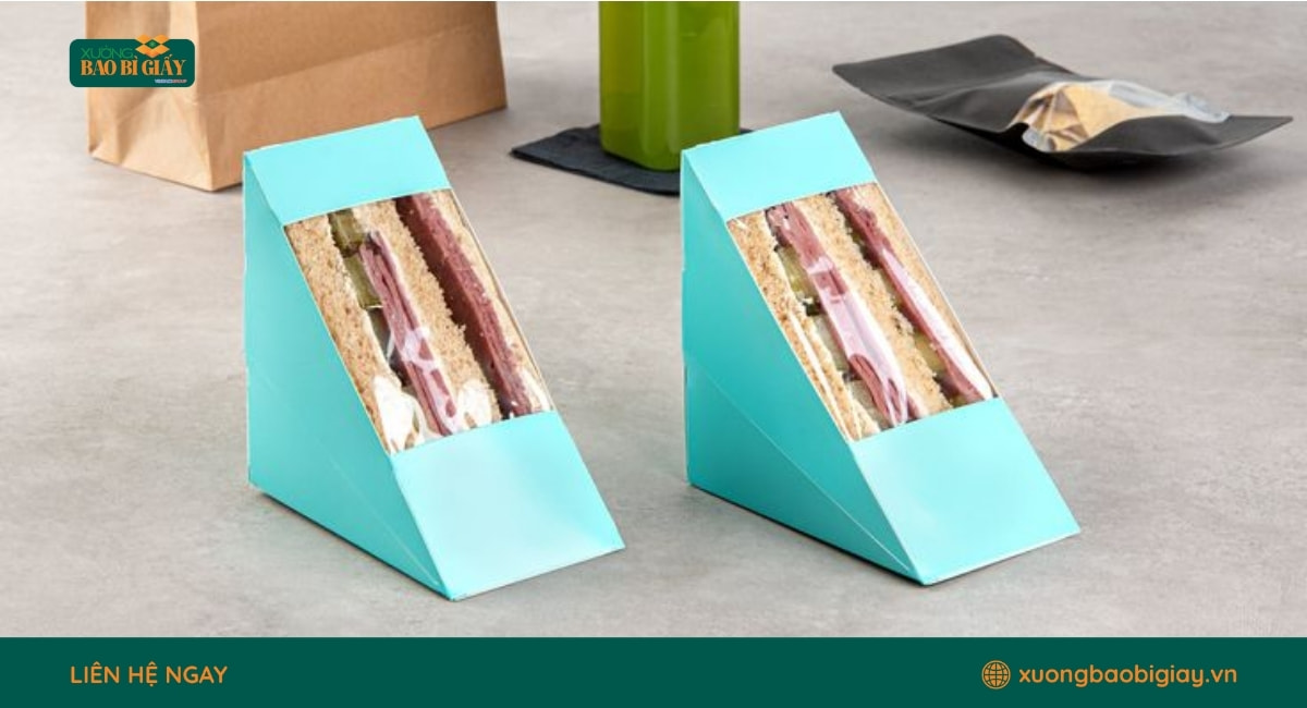 Hộp giấy tam giác đựng sandwich mặt kính, giúp khách hàng dễ quan sát sản phẩm bên trong.